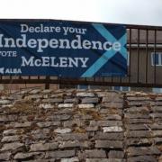 The banner promoting the campaign of Chris McEleny has been placed on railings in Inverclyde