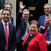 Keir Starmer waves to members of the media after taking a photograph with the new intake of Scottish Labour MPs