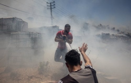 Civilians try to put out fires caused by Israeli missile strikes on targets in Bint Jbeil, Lebanon.