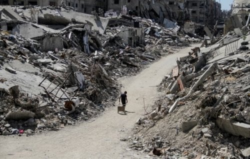 A young Palestinian boy walks amid the rubble of damaged buildings in Beit Lahia, northern Gaza, this week.