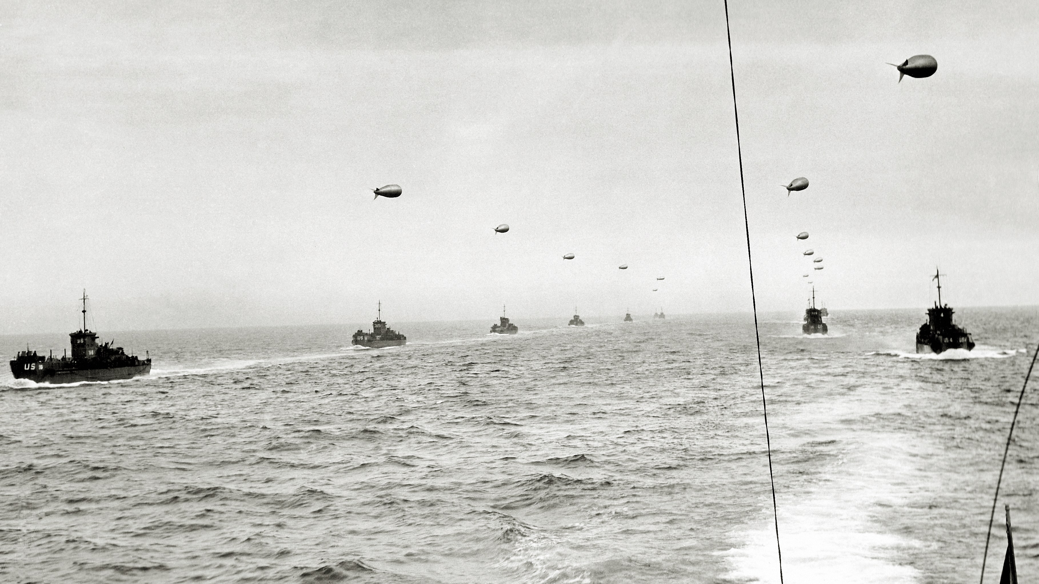 A convoy of landing craft infantry, each with a barrage balloon connected by cable, on June 5, 1944, ready to reach Utah Beach in Normandy the next day, D-Day
