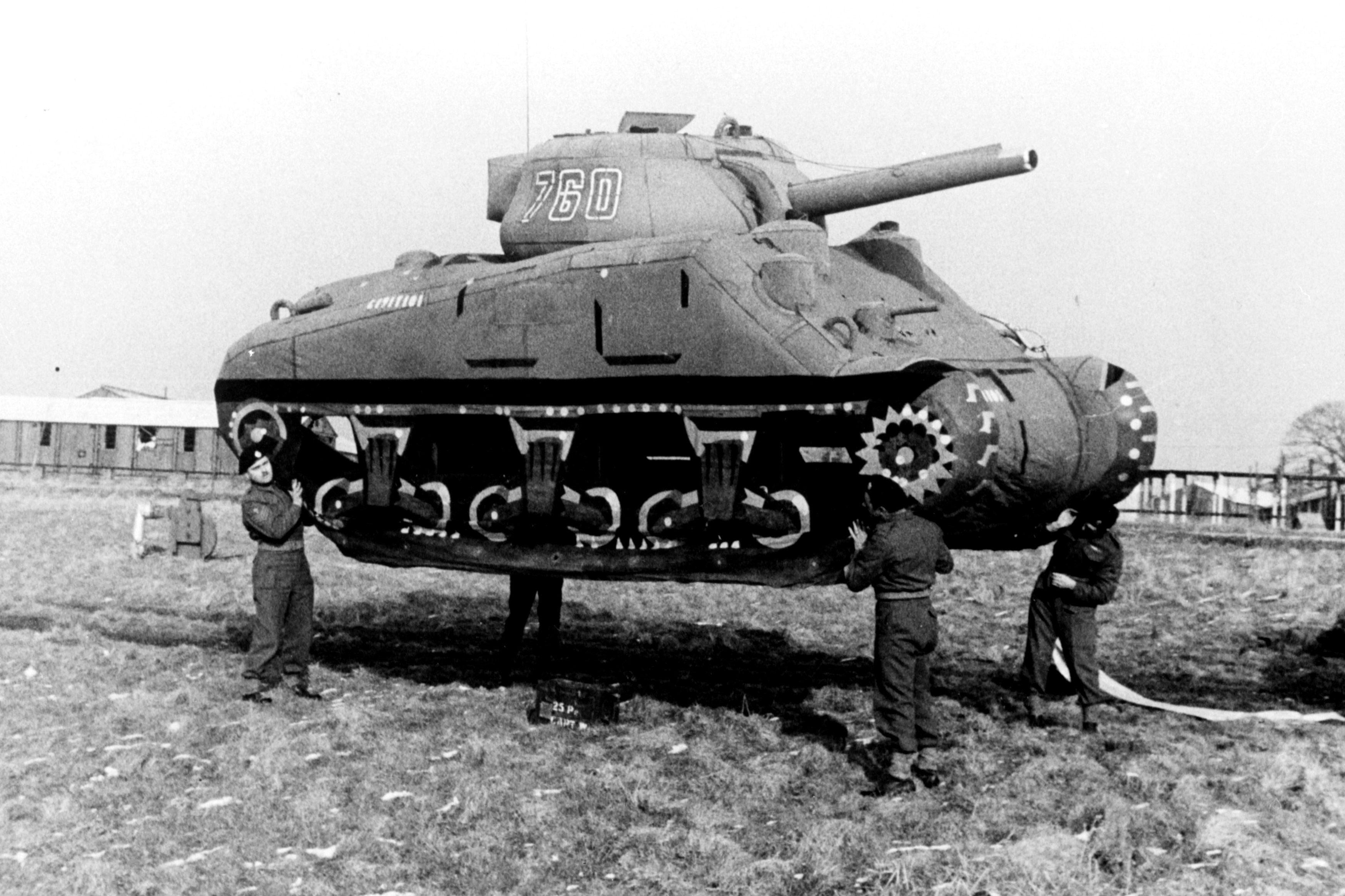 Troops carry a rubber M4 Sherman tank used in the Allied decoy operations