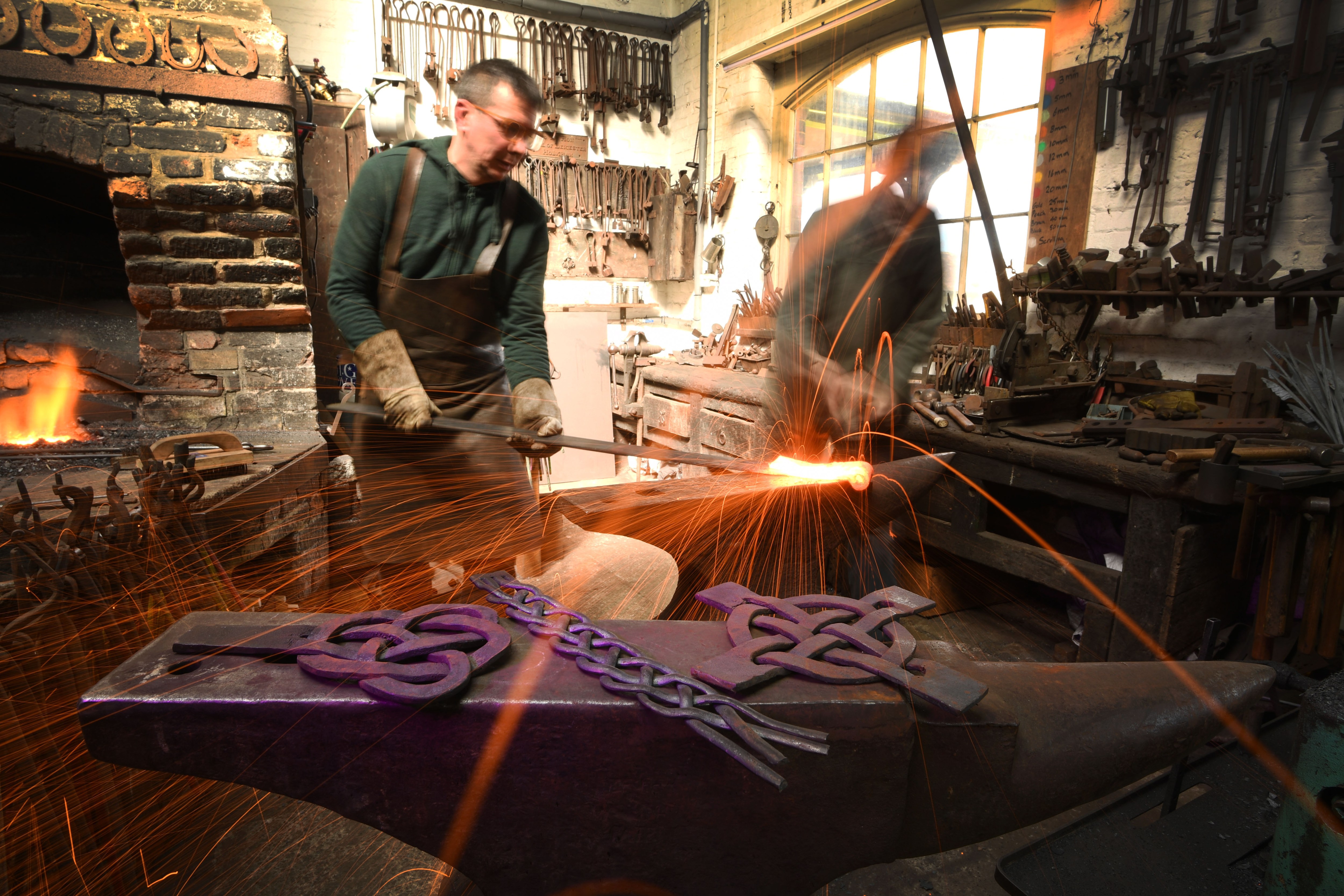 The artist blacksmiths James Spedding and Roger Foyster battle the heat at Holkham forge as they hammer into shape one of over 80 large decorative medieval metal work designs for a commission that will help transform the keep of Norwich Castle into its former glory. As well as crafting decorative door panels, hinges and latches, the pair have also made more than 2,000 traditional fixings, nails and bolts that will bring authenticity to the £15 million Royal Palace Reborn project opening later this year