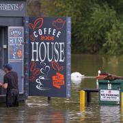 A man moves furniture out of flood water in Wellingborough, Northamptonshire (PA)