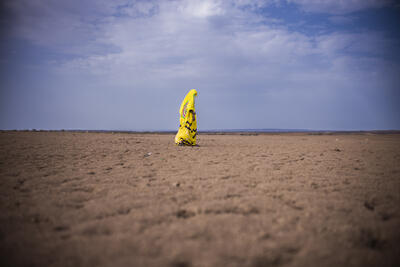 A woman, Esha Mohammed, walks along the dry landscape