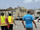 A member of the UN Women’s deployment team is seen walking past a damaged building in Grenada.