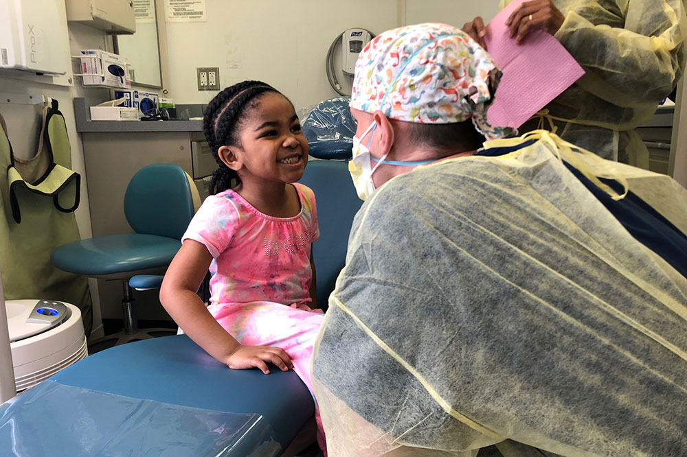 Doctor looking at a smiling child on an exam table