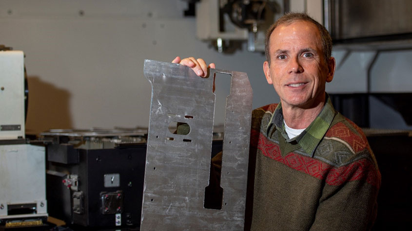 a male inventor smiling in his workshop