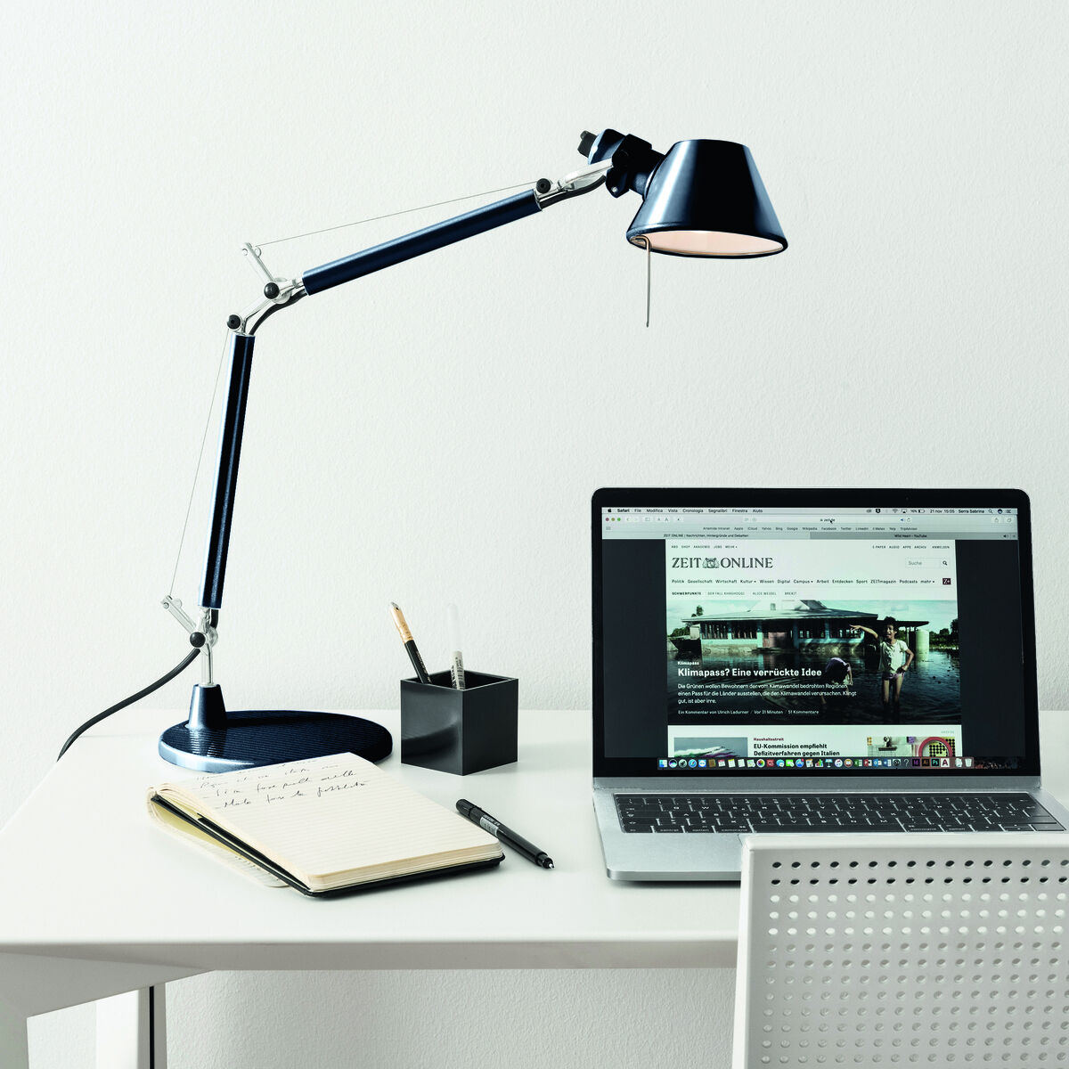 Moderne Tischlampe »Tolomeo Micro« von ZEIT-Sonderedition steht auf einem weißen Schreibtisch. Der Schreibtisch enthält einen Laptop, ein Notebook, einen Stift, einen Kalender und ein Glas Wasser.