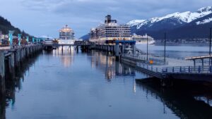 Three cruise ships are docked along Juneau's waterfront on the evening on March 10, as a Princecess Cruise ship on the right is departing the captial city. (Photo by Yereth Rosen/Alaska Beacon)