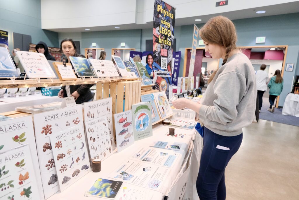 Danielle Brubaker shops for homeschool materials at the IDEA Homeschool Curriculum Fair in Anchorage on April 18, 2024. A court ruling struck down the part of Alaska law that allows correspondence school families to receive money for such purchases. (Photo by Claire Stremple/Alaska Beacon)