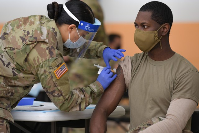 U.S. Army Spc. Eyza Carrasco, left, with 2nd Cavalry Regiment, administers a COVID-19 vaccination at the 7th Army Training Command&#39;s (7ATC) Rose Barracks, Vilseck, Germany, May 3, 2021. The U.S. Army Health Clinics at Grafenwoehr and Vilseck conducted a &#34;One Community&#34; COVID-19 vaccine drive May 3-7 to provide thousands of appointments to the 7ATC community of Soldiers, spouses, Department of the Army civilians, veterans and local nationals employed by the U.S. Army.