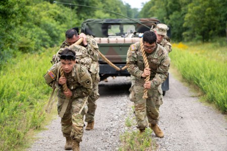 Soldiers pull a vehicle along a dirt road during the Warhammer Stakes at Fort Chaffee, Ark., June 12, 2023. The Warhammer Stakes is an endurance competition that includes a grueling ruck march, a litter carry and a sandbag run.
