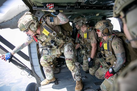 An Army Special Forces team sergeant spots a high-altitude release point as other soldiers watch during military free-fall training operations in Tuzla, Bosnia-Herzegovina, June 22, 2023. (This photo has been altered for security purposes.)