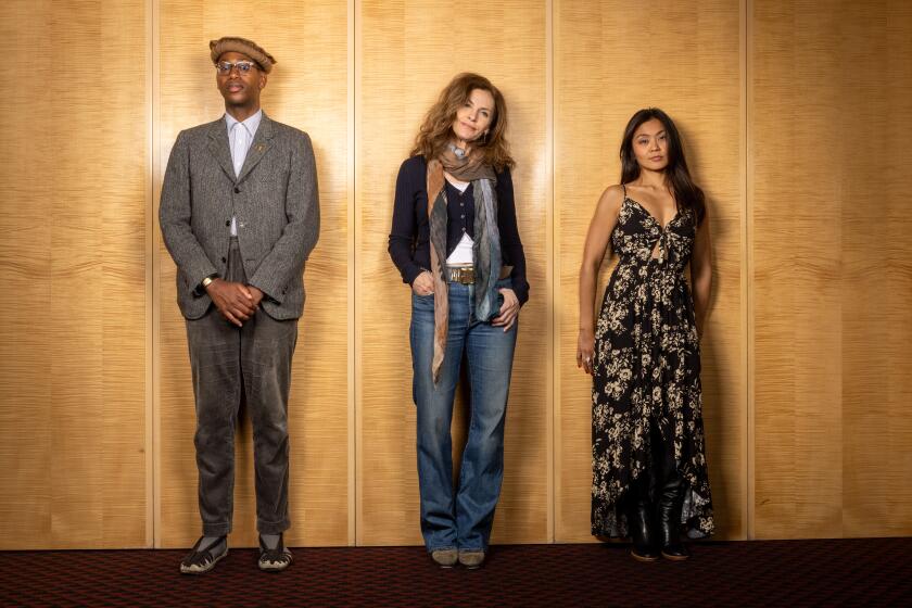 A man and two women standing against a wall