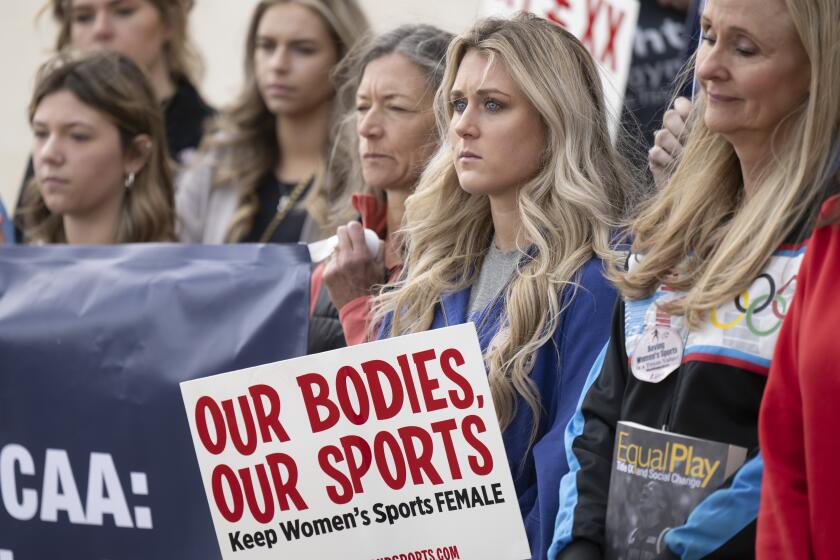FILE - Former University of Kentucky swimmer Riley Gaines, second from right, stands during a rally.