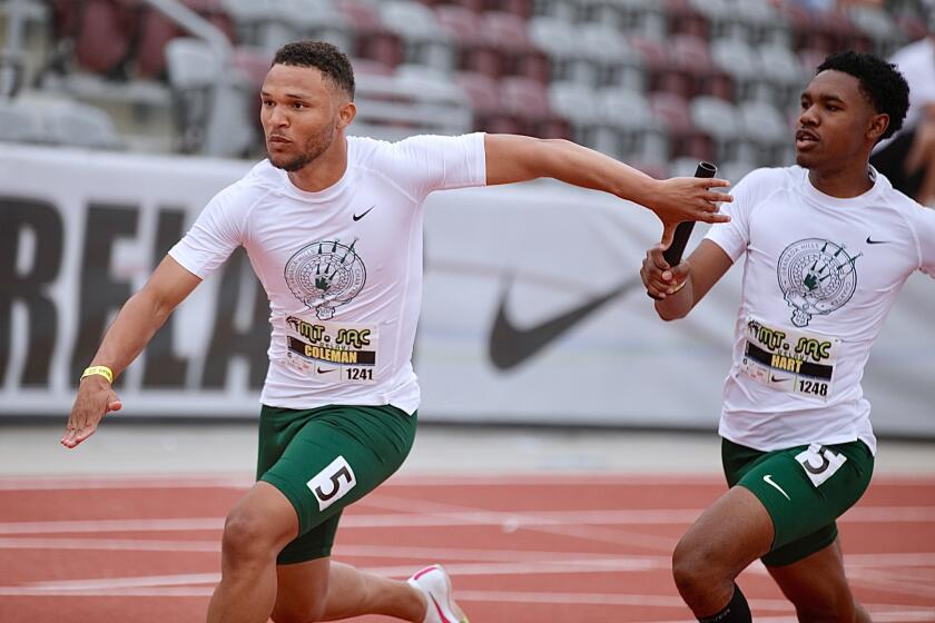 Granada Hills sprinter Jordan Coleman reaches back to receive the baton from teammate Justin Hart.