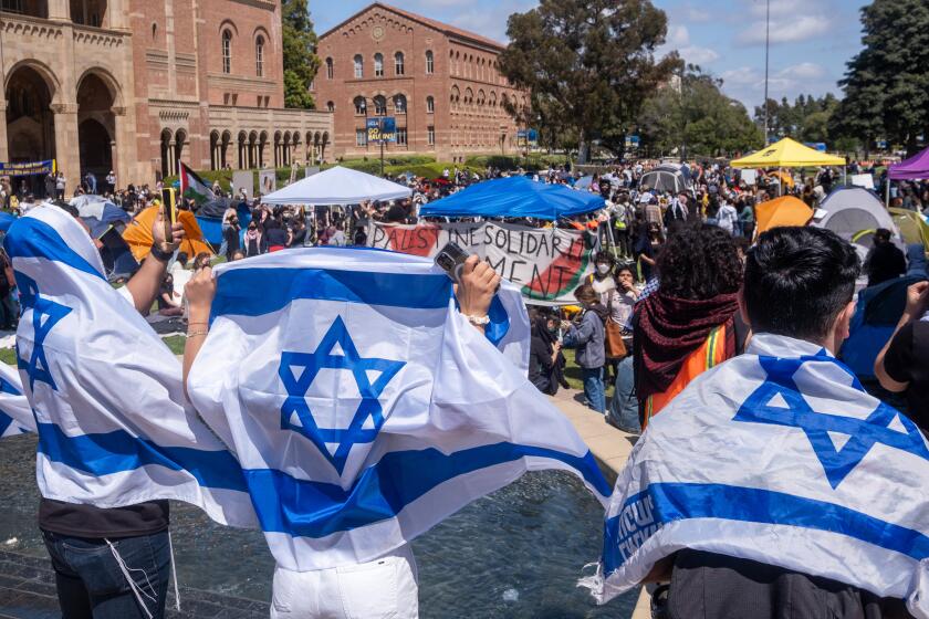 Los Angeles, CA - April 25: Pro-Israeli protesters with their flags gather near an encampment set up by pro-Palestine protesters on the campus of UCLA at UCLA Thursday, April 25, 2024 in Los Angeles, CA. (Ringo Chiu / For The Times)