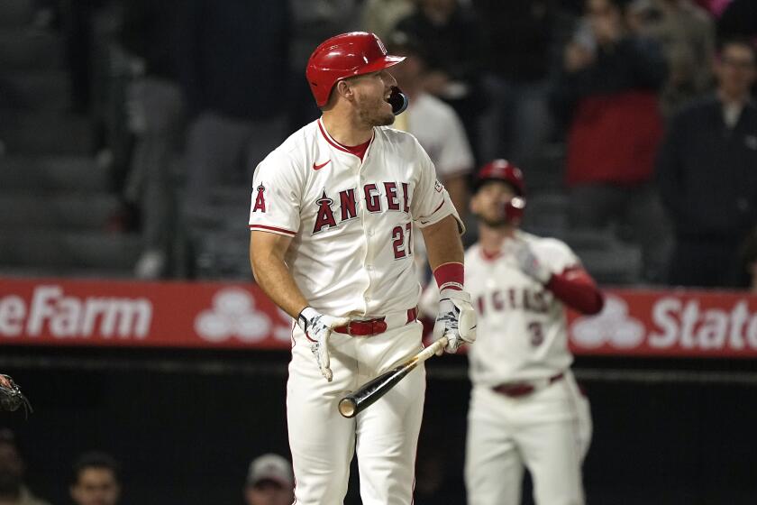 Los Angeles Angels' Mike Trout, center, reacts after striking out to end the baseball game.
