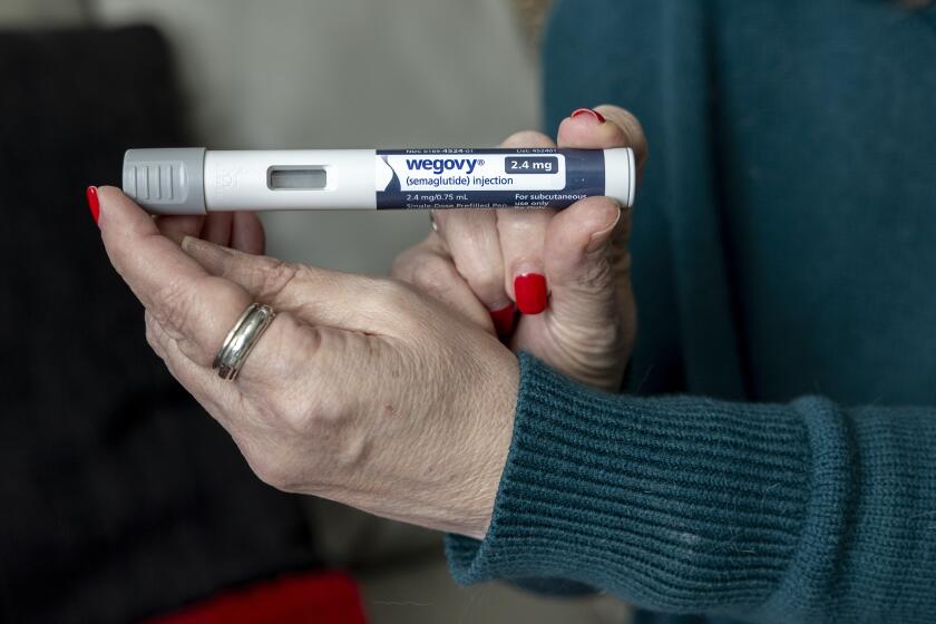 Donna Cooper holds up a dose of Wegovy, a drug used for weight loss.