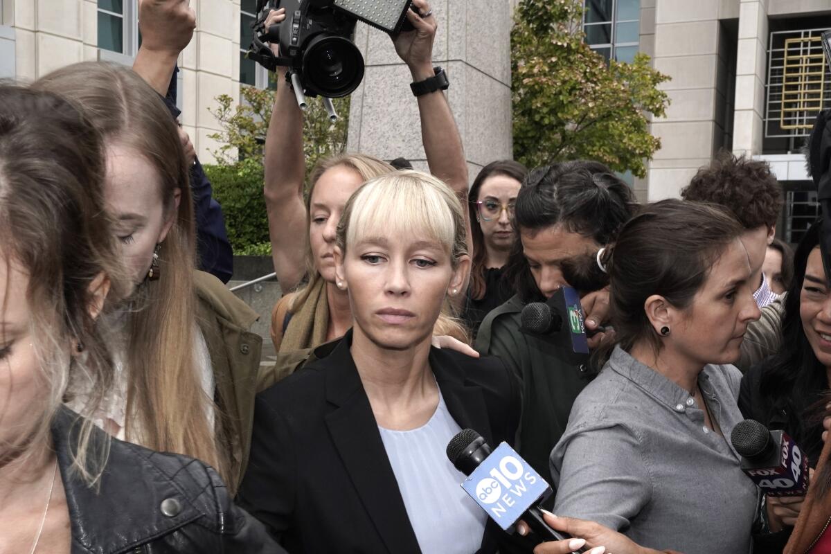 Sherri Papini, standing among a crowd with a microphone held near her face