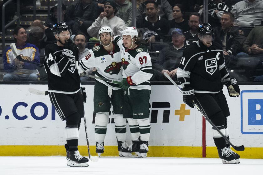 Minnesota Wild right wing Ryan Hartman (38) and left wing Kirill Kaprizov (97) celebrate after Hartman's goal during the second period of an NHL hockey game against the Los Angeles Kings, Monday, April 15, 2024, in Los Angeles. (AP Photo/Kyusung Gong)