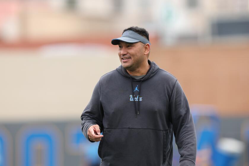 UCLA defensive coordinator Ikaika Malloe smiles while looking across the field during a spring football practice.