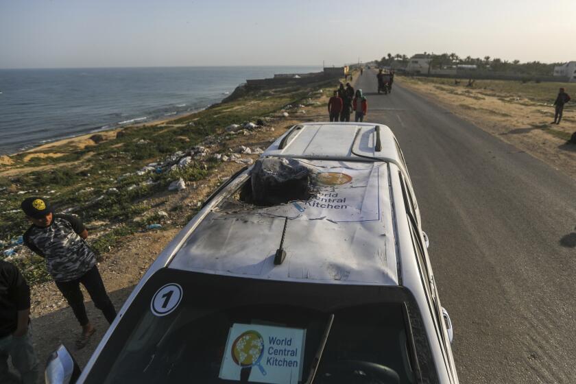 FILE - Palestinians inspect a vehicle with the logo of the World Central Kitchen wrecked by an Israeli airstrike in Deir al Balah, Gaza Strip, April 2, 2024. A memorial at the National Cathedral in Washington, on April 25, will honor seven World Central Kitchen aid workers killed by Israeli strikes in Gaza earlier this month. (AP Photo/Ismael Abu Dayyah, File)