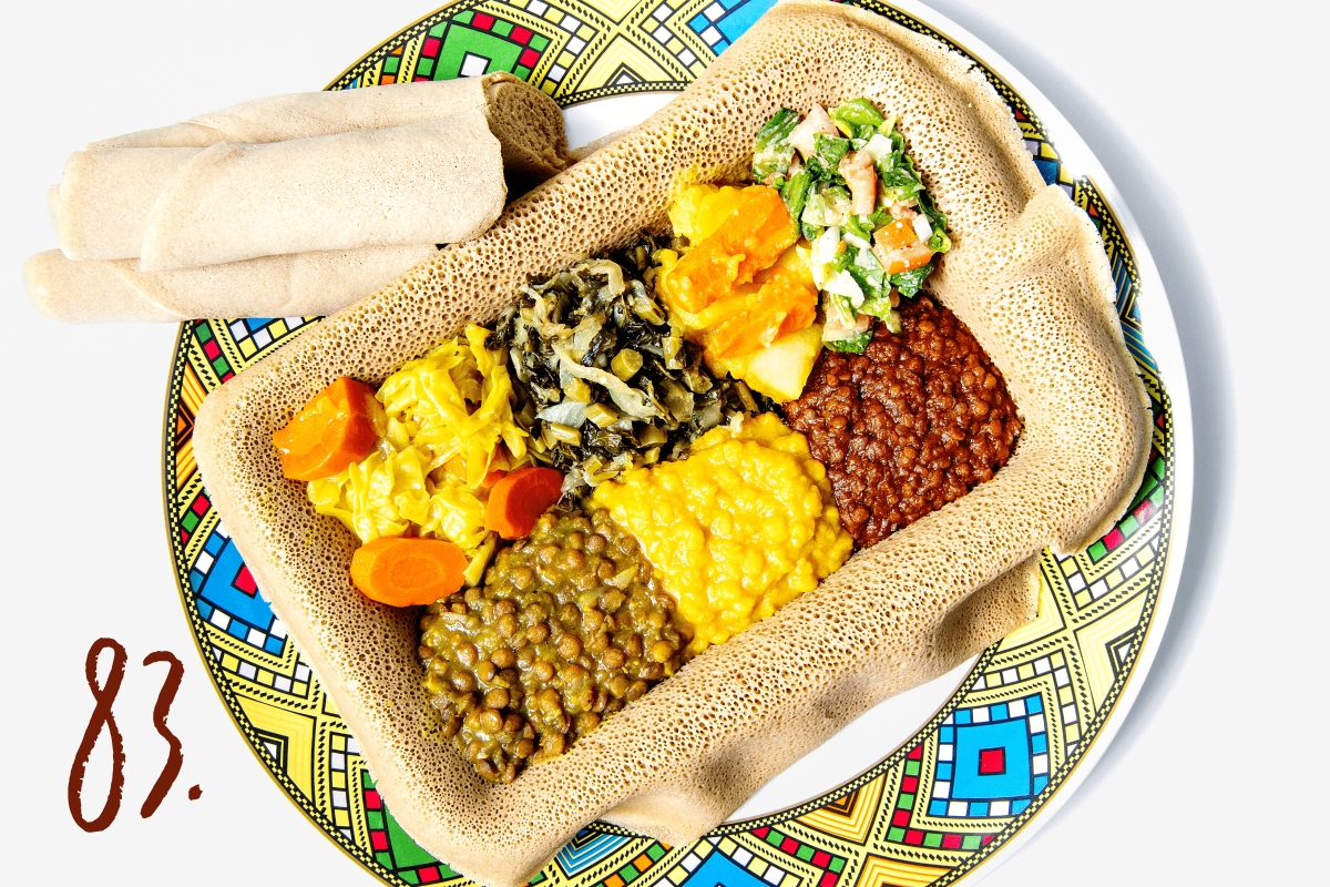 #83: Several veggie dishes on injera