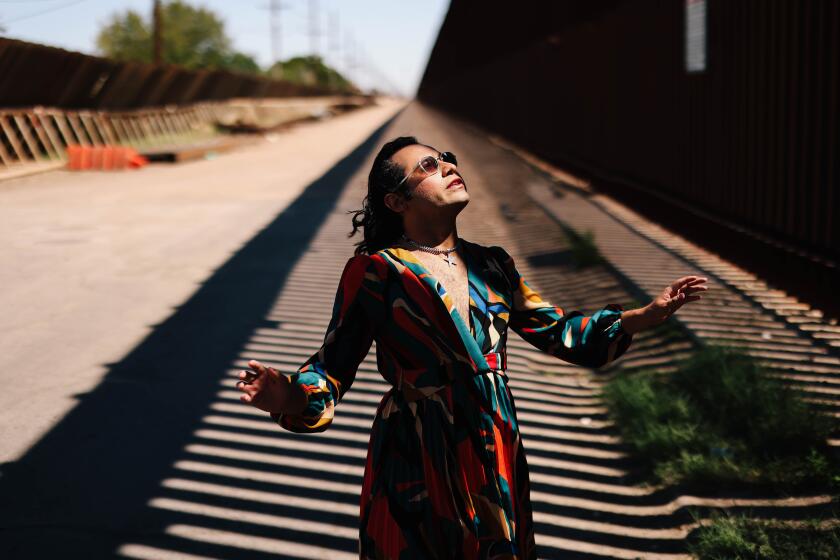 Calexico, CA - March 25: Raul Urena, the first transgender mayor of Calexico and current council member, poses for a portrait in front of the USA-Mexico border wall on Monday, March 25, 2024 in Calexico, CA. He is facing a recall election in mid-April and he believes gender plays a big role in it. (Dania Maxwell / Los Angeles Times)