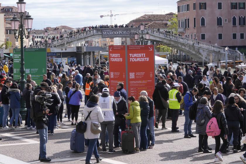 Stewards check tourists QR code access outside the main train station in Venice, Italy, Thursday, April 25, 2024. The fragile lagoon city of Venice begins a pilot program Thursday to charge daytrippers a 5 euro entry fee that authorities hope will discourage tourists from arriving on peak days. The daytripper tax is being tested on 29 days through July, mostly weekends and holidays starting with Italy's Liberation Day holiday Thursday. Officials expect some 10,000 people will pay the fee to access the city on the first day, downloading a QR code to prove their payment, while another 70,000 will receive exceptions, for example, because they work in Venice or live in the Veneto region. (AP Photo/Luca Bruno)