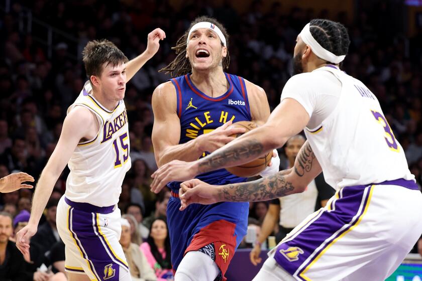 Los Angeles, California March 2, 2024-Nuggets Aaron Gordon drives between Austin Reaves.