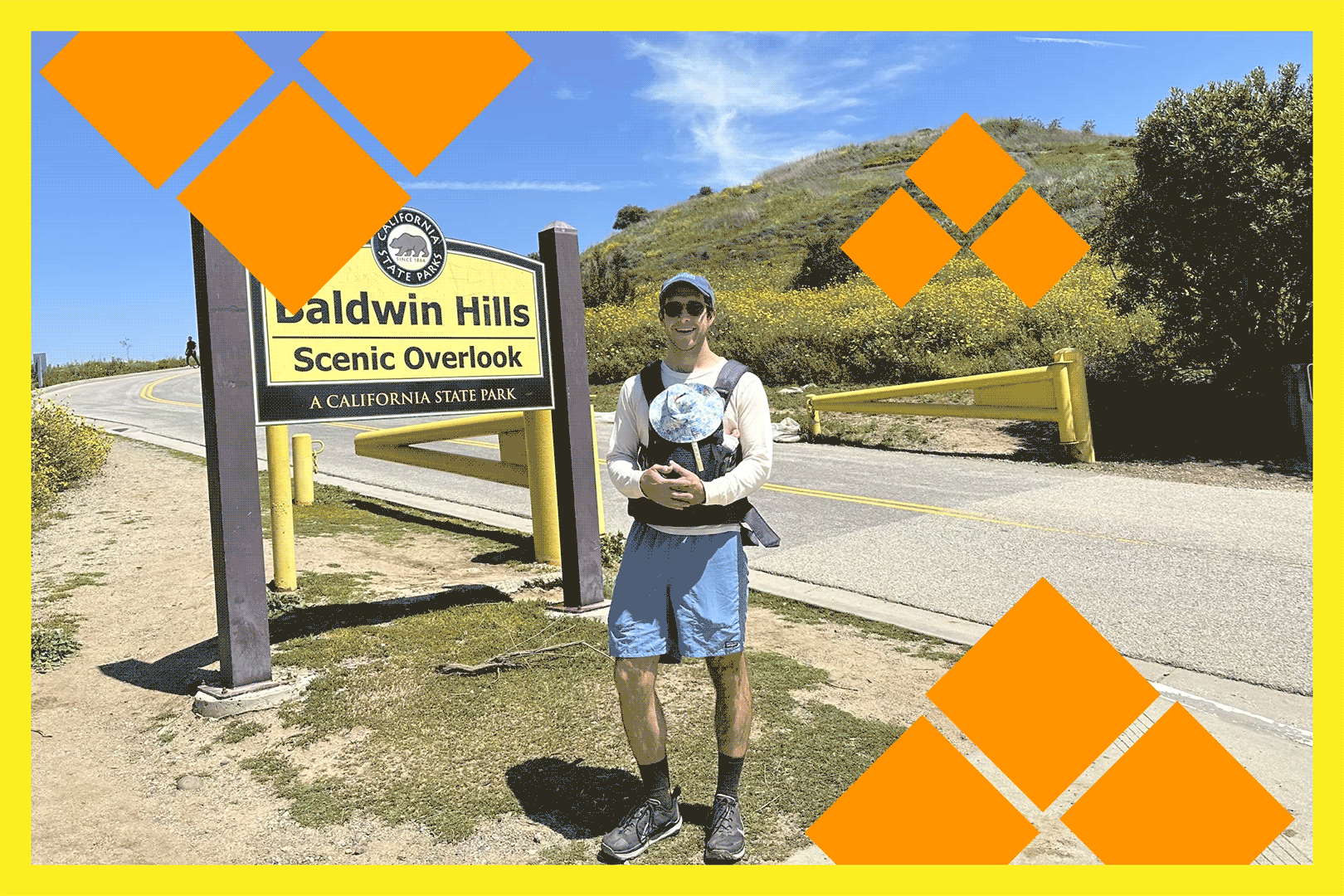A man holding a newborn at the trailhead for a hike
