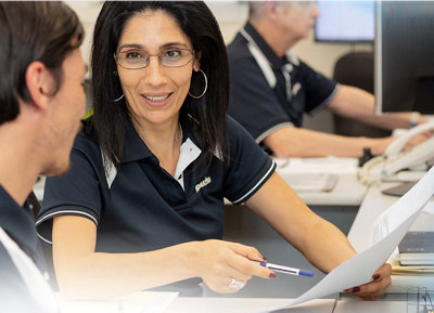 A women explaining to another person pointing her pen onto a paper