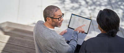 Two people looking at a laptop screen.