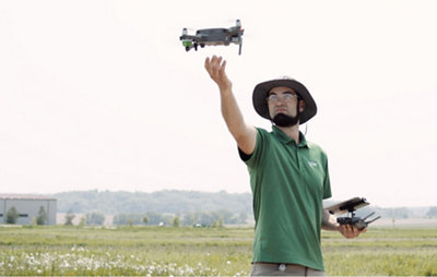 A man is flying a drone in a field.