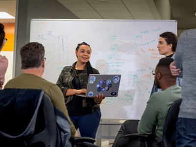 A girl standing in front of a whiteboard giving a presentation