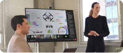 Teams 会議中に Microsoft Surface Hub 2S でデータを提示する女性