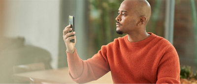 ある男性が携帯電話で写真を撮っています。