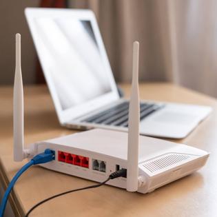  Internet router on working table with blurred laptop in the background.