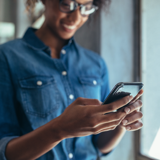 A woman holds a phone in her hands.