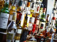 Several types of bottled alcohol are displayed on some shelves in a pub in Bucharest, Romania.