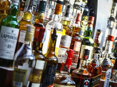 Several types of bottled alcohol are displayed on some shelves in a pub in Bucharest, Romania.