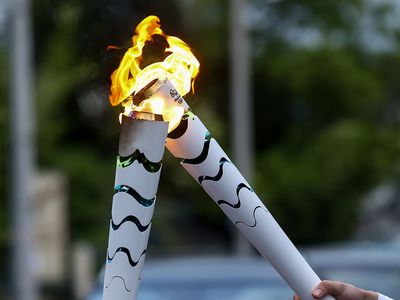 Corfu, Greece - April 23, 2016: The Olympic flame is symbolically passed from one torch to another after the official ceremonial lighting