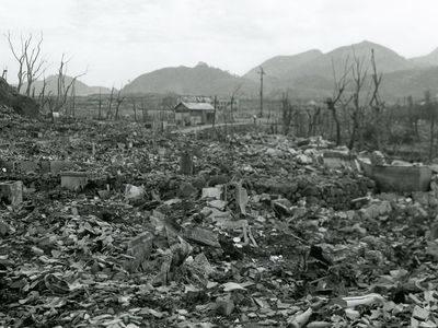 View of the area destroyed by the atomic bomb explosion at Nagasaki, Japan, showing rubble, decimated trees, and one small structure still standing at center, 16 September 1945. (World War II)