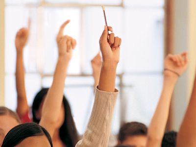 Students raising their hands in a classroom