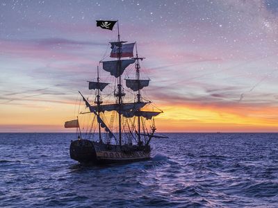 Pirate Ship leaving the harbor at the milky way sunset for a long campaign against the loyal marines on the oceans