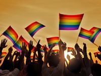 Silhouettes of People Holding Gay Pride Symbol Flag