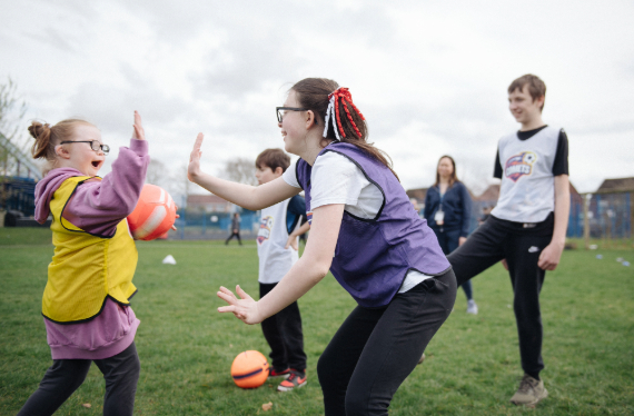 Two players high-five at Comets Disability Football session