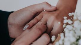 Мужчина надевает женщине обручальное кольцо на палец